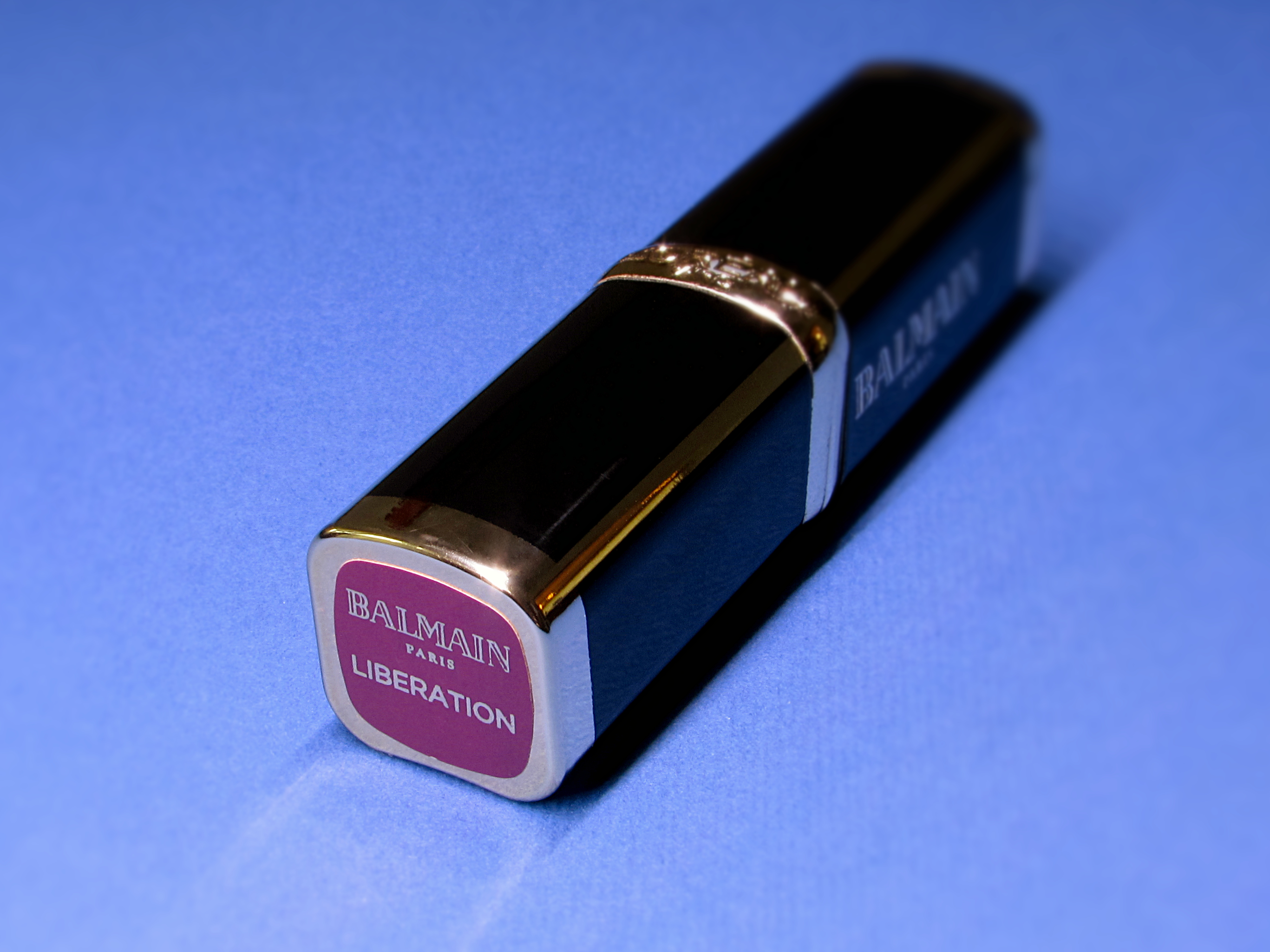 L’Oréal Paris x Balmain Color Riche limited edition purple lipstick in 468 Liberation closed on a blue background.