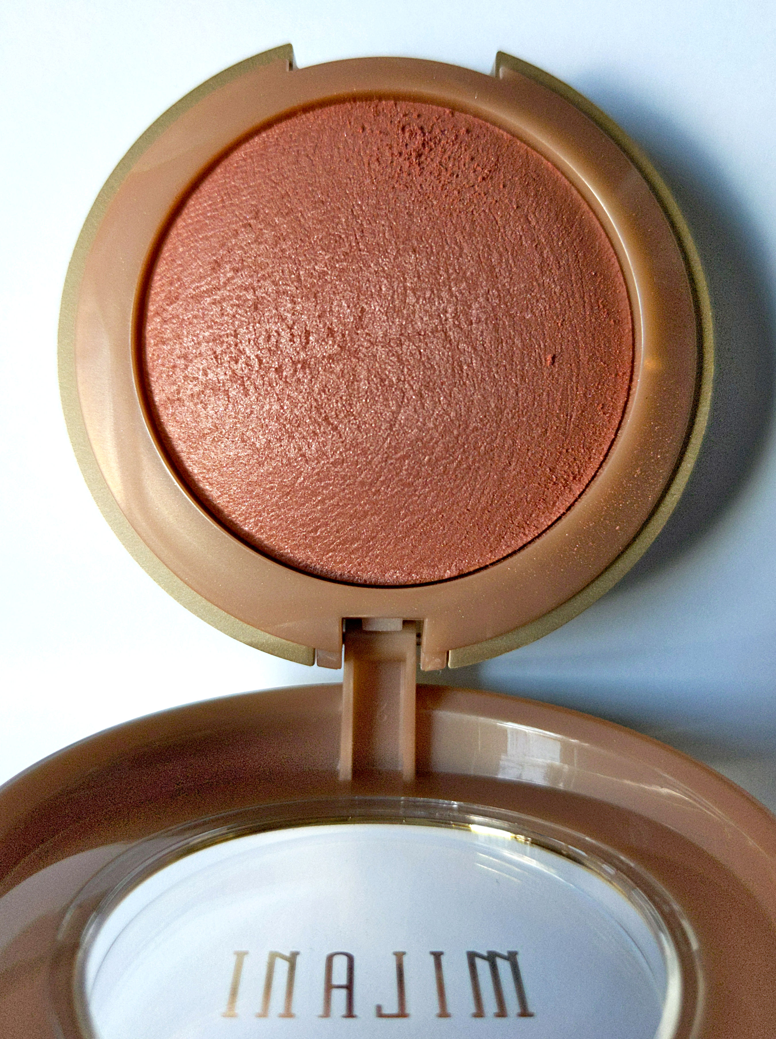 A close-up of Milani Baked Powder Blush in 15 Sunset Passione.
